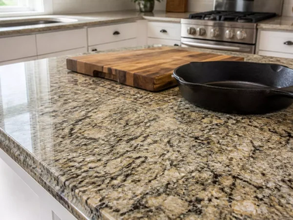 Polished granite countertop with natural speckled pattern, cutting board and cast-iron pan
